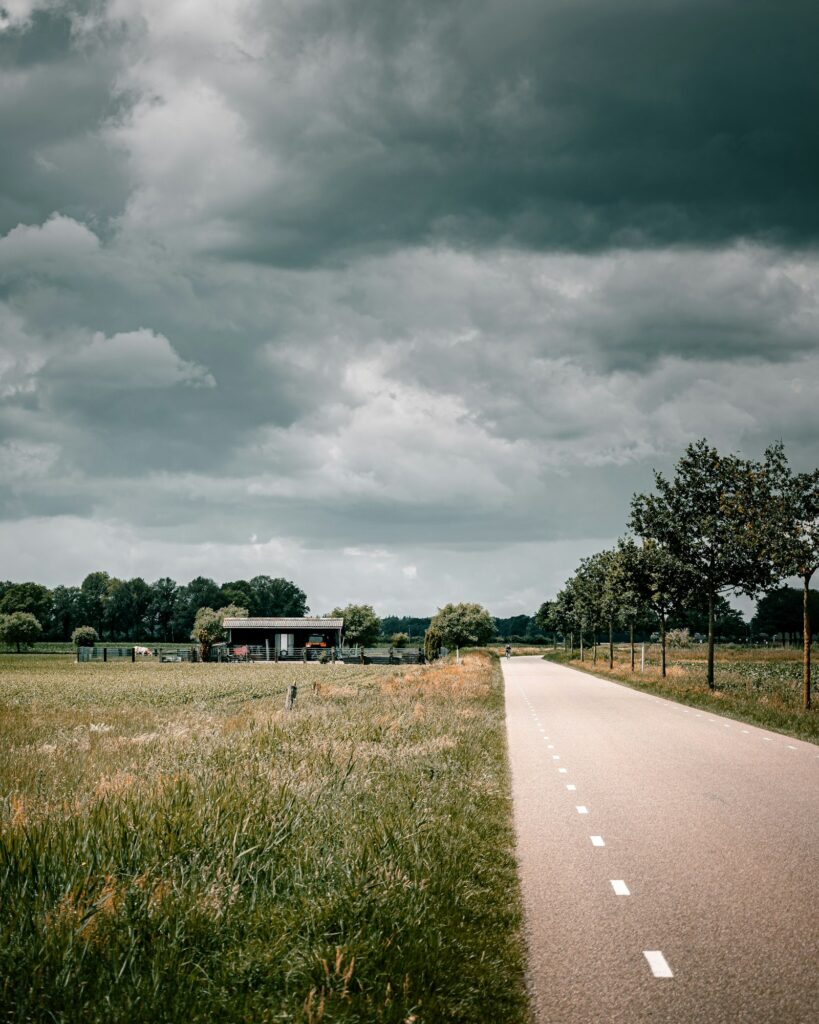 Country road near the city of Eindhoven in the Netherlands against a clouded sky
